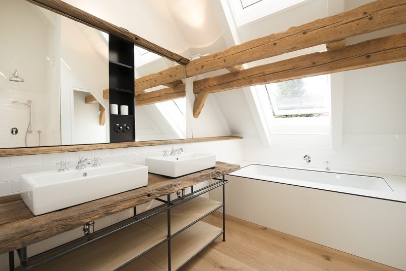 Salle de bains avec poutres en bois dans une ancienne grange