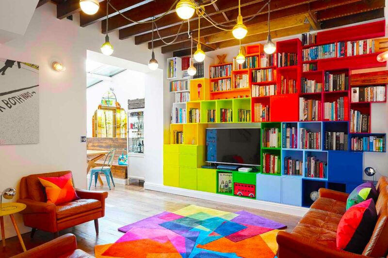 Salon avec tapis à la forme irrégulière assorti à la bibliothèque modulable colorée